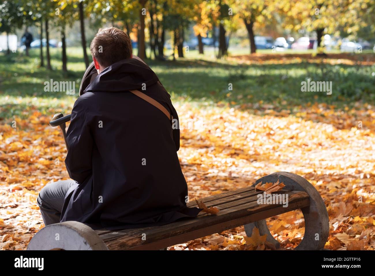 Felice padre giovane con pam seduto su panchina in natura al parco Foto Stock
