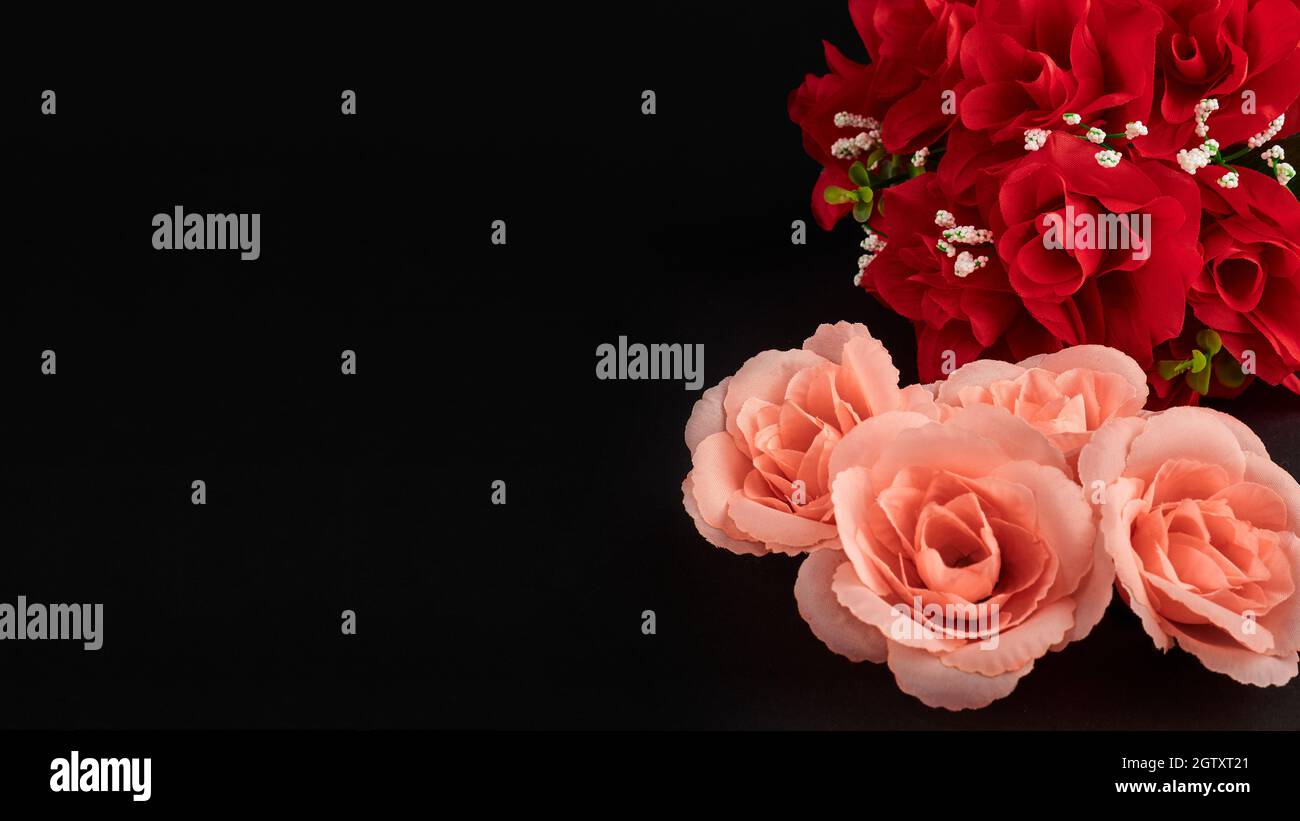 Primo piano del bouquet decorativo di rose rosse artificiali su sfondo nero Foto Stock