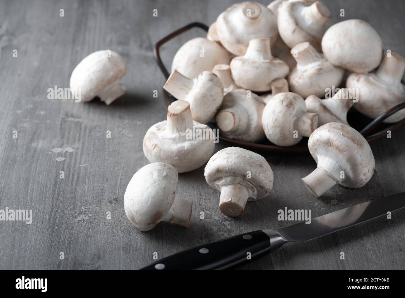 Funghi freschi crudi su un tavolo di legno Foto Stock