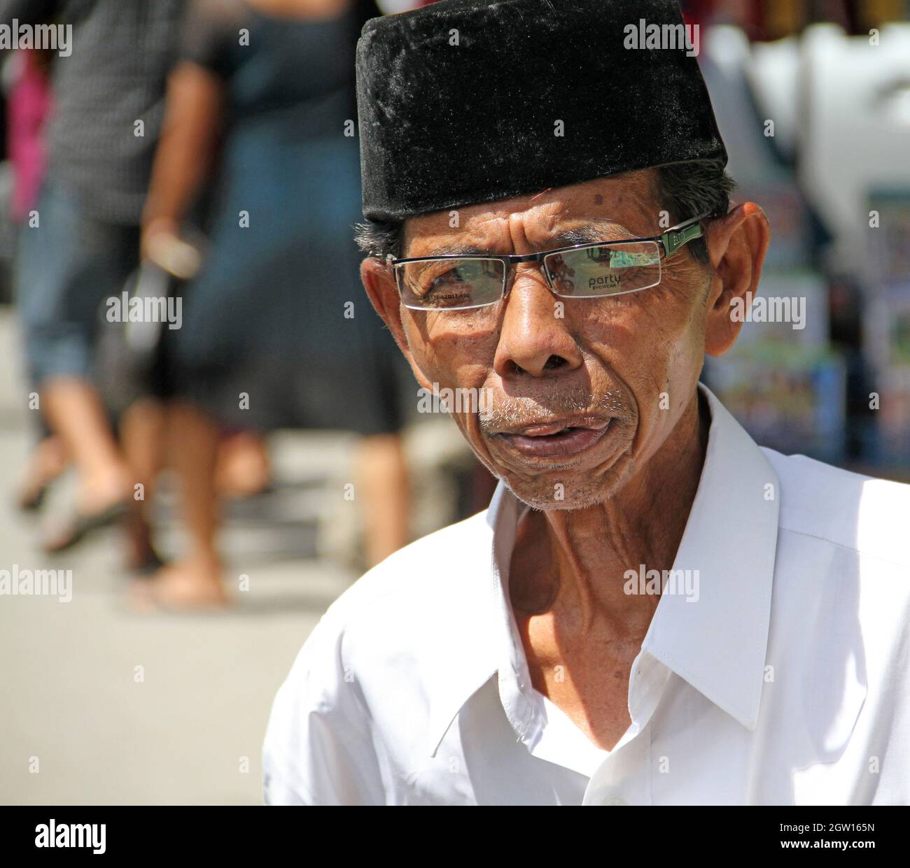 Un uomo musulmano anziano che indossa occhiali e un Songkok o Peci o Kopiah a Padang City, West Sumatra, Indonesia. Foto Stock