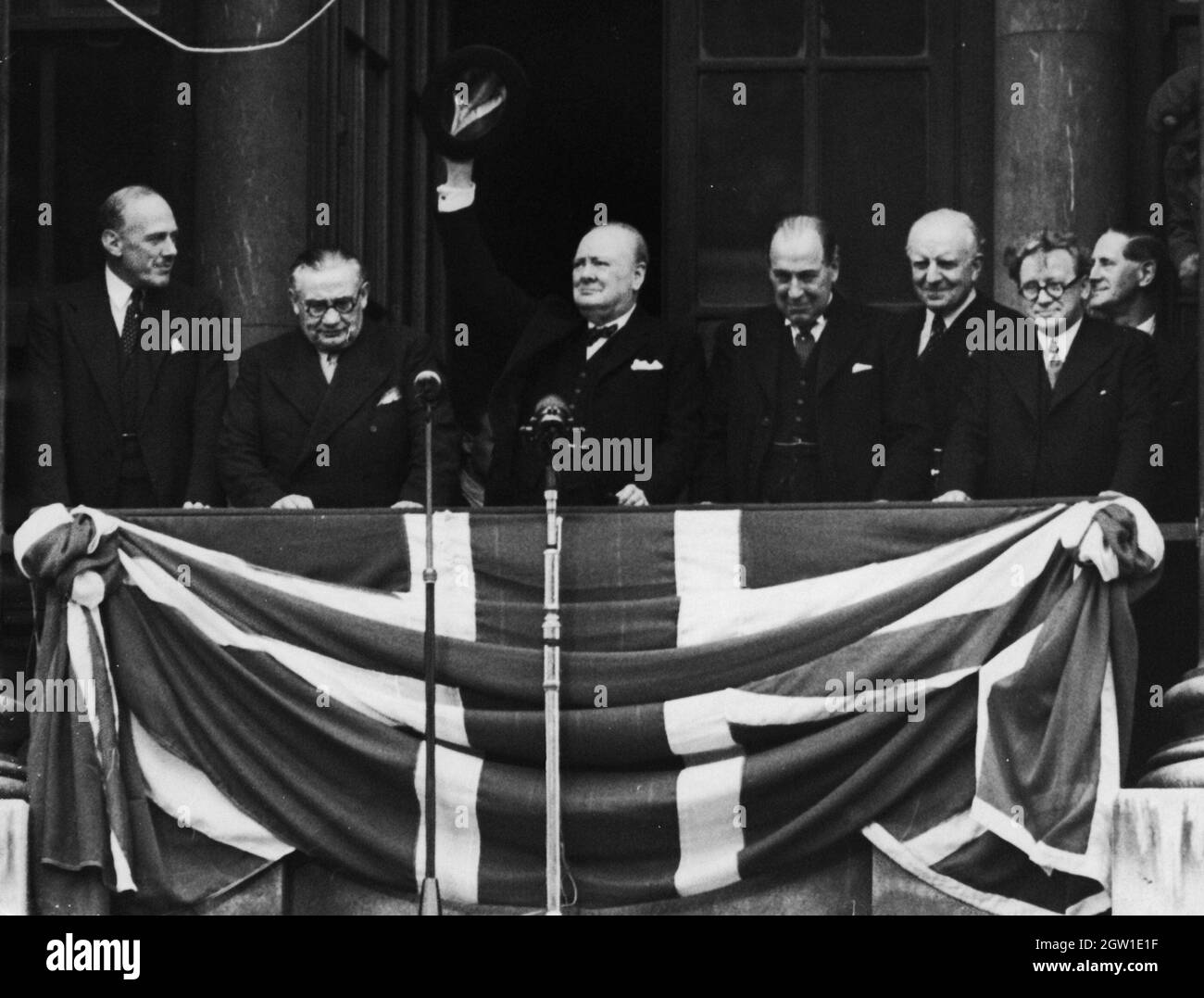 Il primo ministro britannico Winston Churchill si rivolge alle folle dal balcone del Ministero della Salute a Whitehall il VE Day, 8 maggio 1945. Da sinistra a destra, Ernest Bevin, Churchill, Sir John Anderson, Lord Woolton e Herbert Morrison Foto Stock