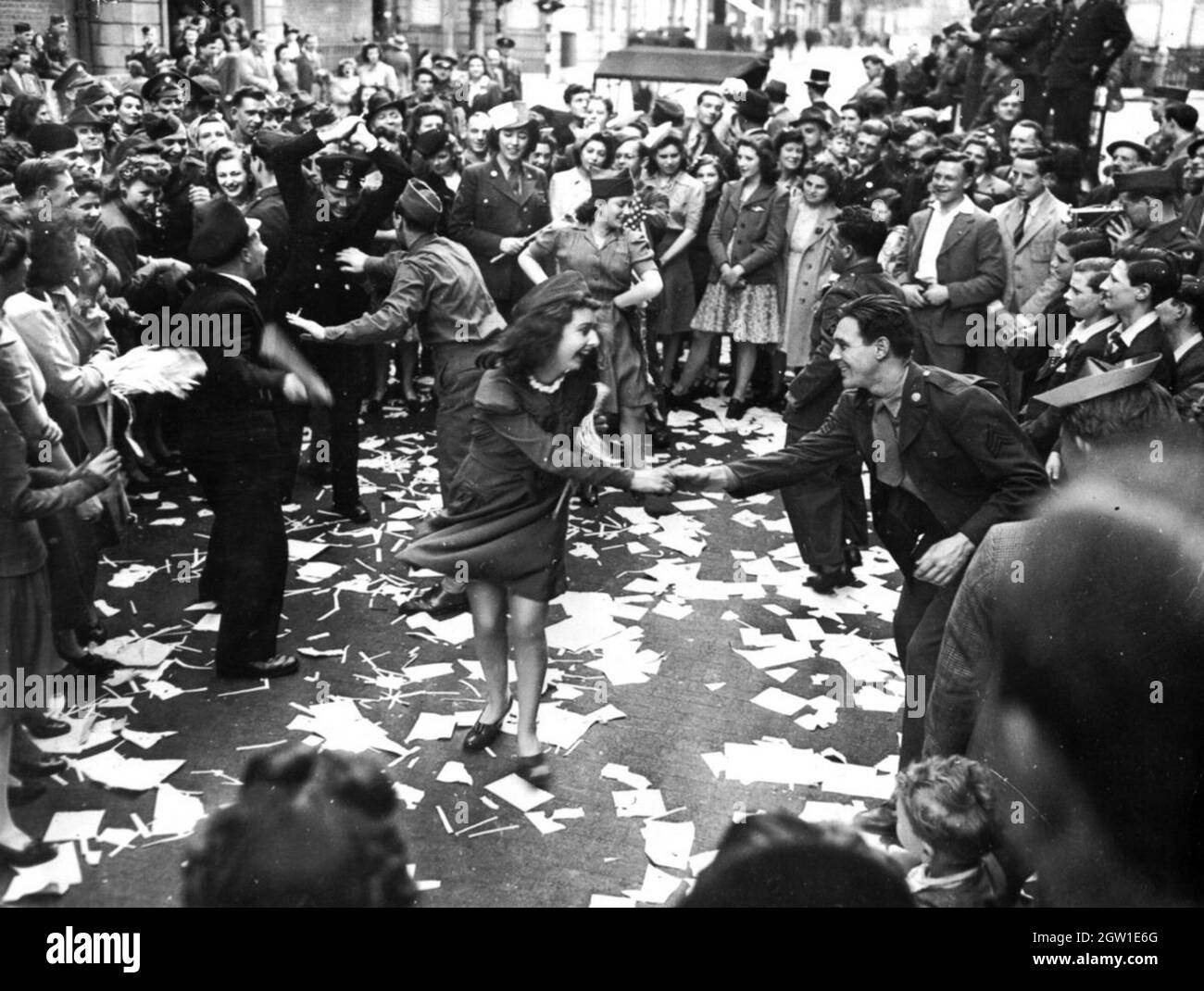 Le persone che ballano per le strade in occasione del VE Day (giorno della Vittoria in Europa), l'8 maggio 1945 Foto Stock