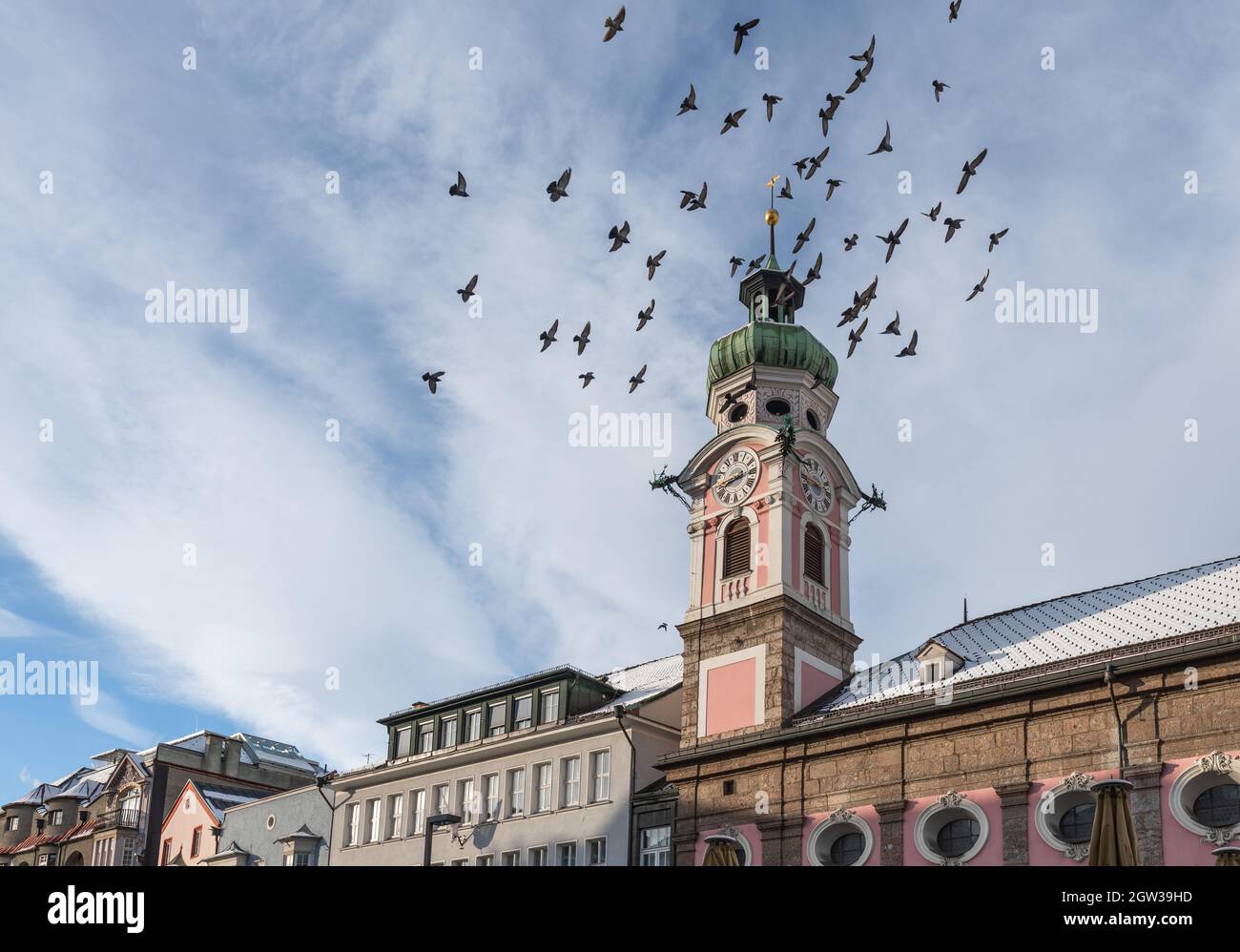 Uccelli che volano vicino alla Chiesa ospedaliera della Torre dello Spirito Santo (Spitalskirche) - Innsbruck, Tirolo, Austria Foto Stock