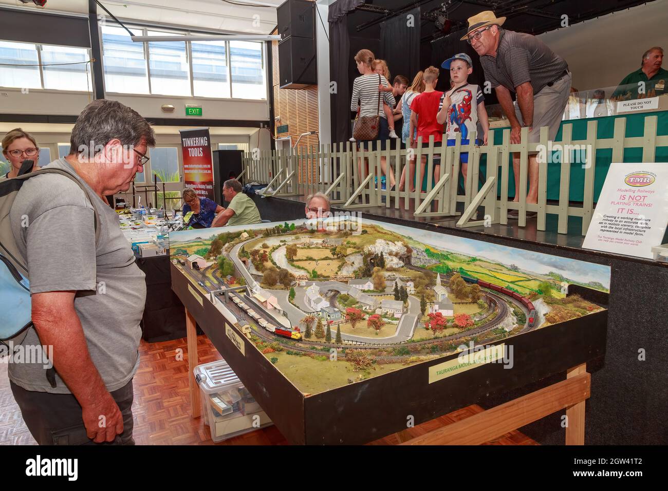 Persone che guardano un'esposizione di un modello di treno mostra Foto Stock