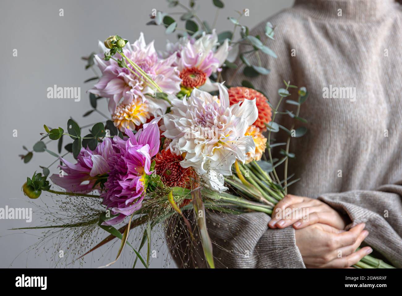 Bouquet festivo luminoso con fiori di crisatema in mani femminili, fiori luminosi. Foto Stock