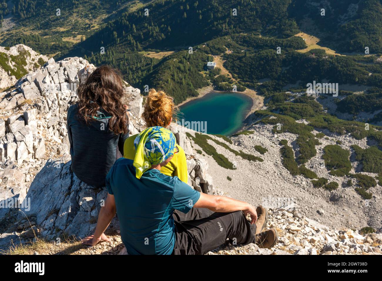 Escursioni in Bulgaria gruppo misto di escursionisti sulla cima di Sinanitsa a 2516 m che si affaccia sul lago Sinanitsa e capanna (2181 m) sul monte Pirin, Bulgaria Foto Stock