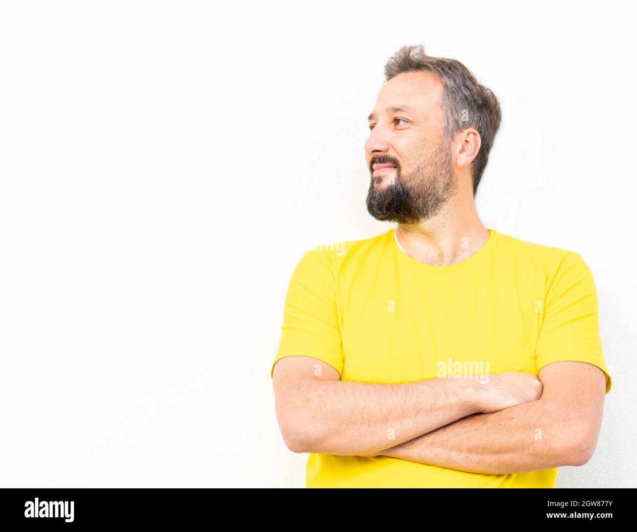 Un uomo positivo con ritratto giallo della camicia contro il muro Foto Stock
