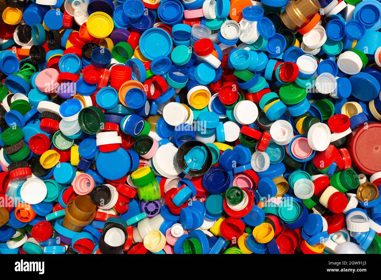 Migliaia di diversi cappucci di plastica colorati sono visti impilati per il riciclaggio. Foto Stock