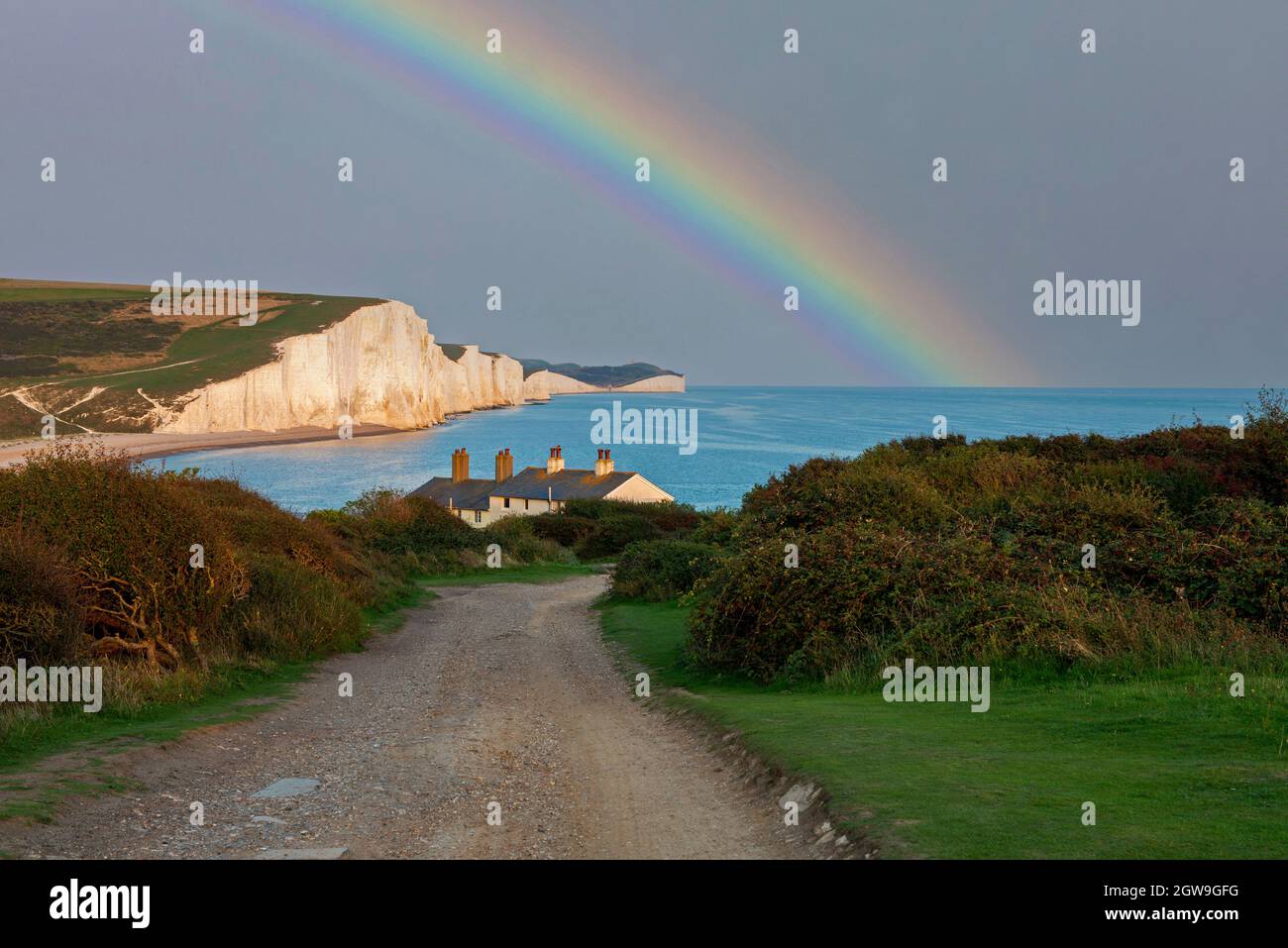 Un arcobaleno sopra le sette Sorelle e Cottages di Coastguard, Seaford, Sussex orientale, Regno Unito Foto Stock