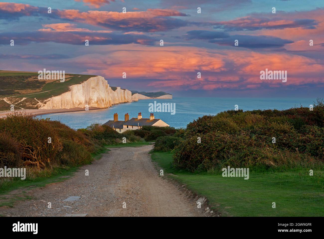 Le sette Sorelle e Cottages Coastguard al tramonto. Seaford, East Sussex, Regno Unito Foto Stock