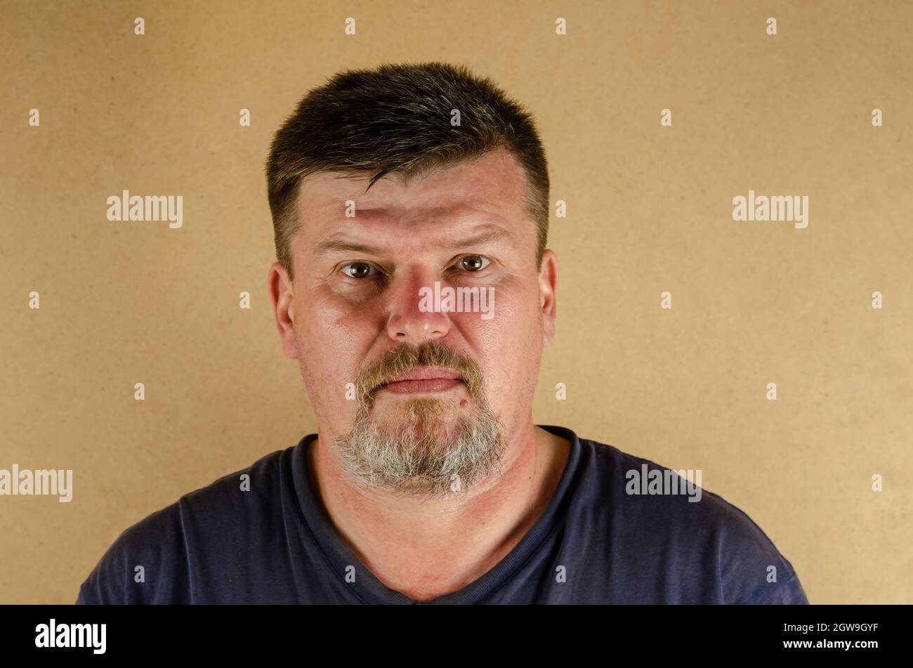 Ritratto di un uomo di 45 anni che guarda la fotocamera. Adulto non rasare il maschio in ambienti chiusi. Foto Stock