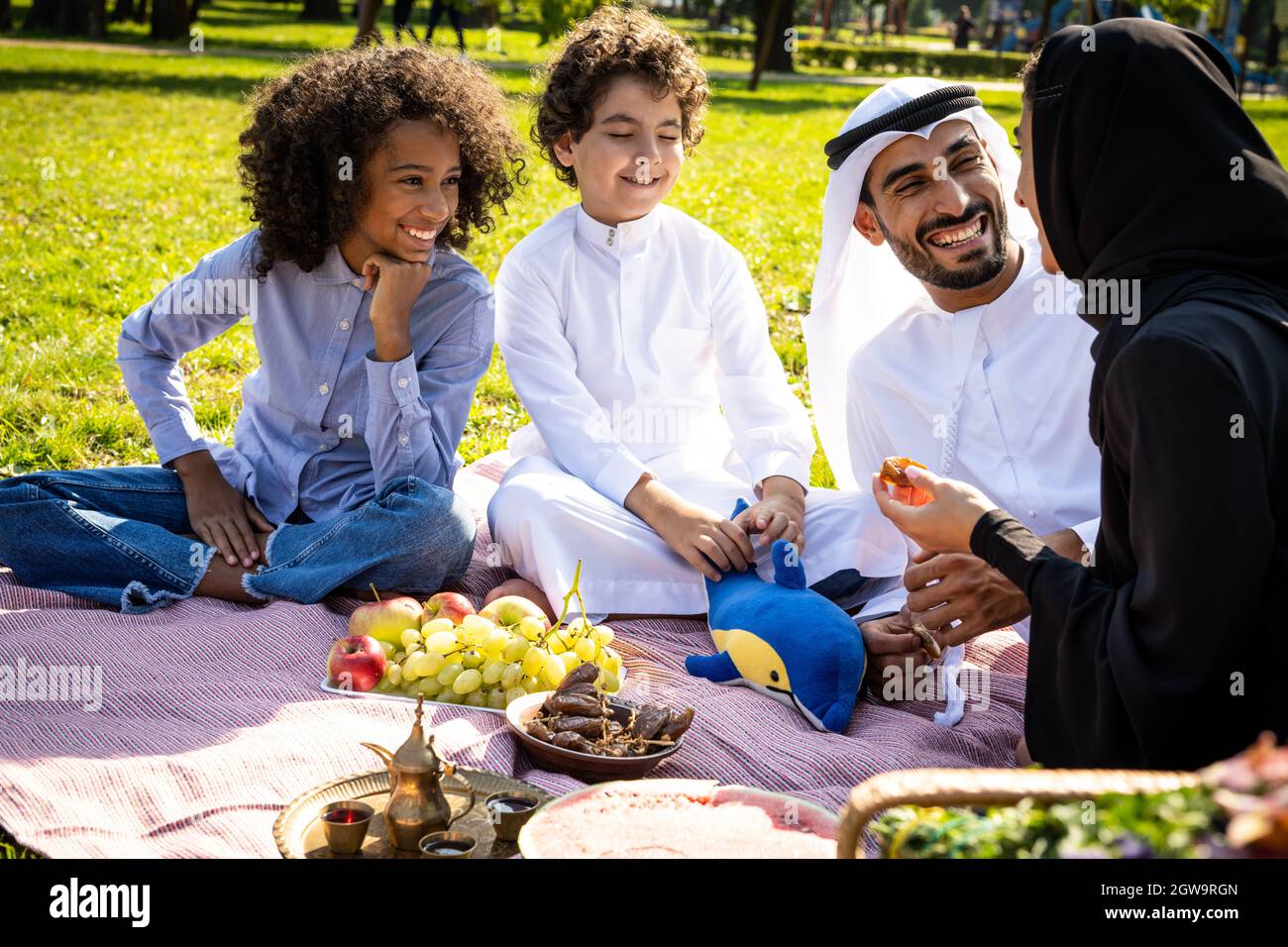 immagine cinematografica di una famiglia degli emirates che trascorre del tempo al parco Foto Stock