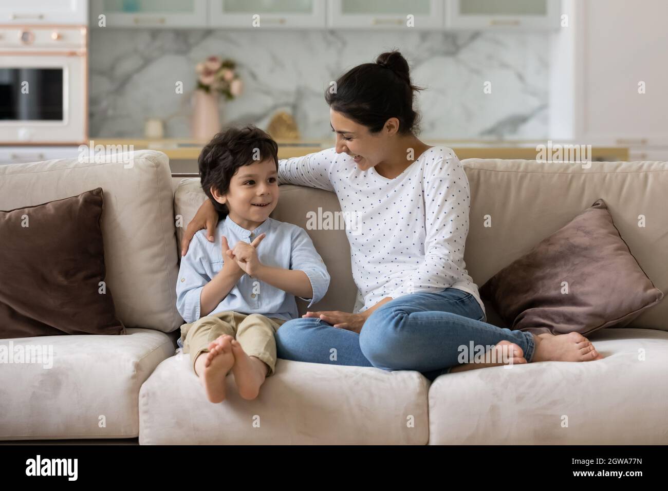 Cura giovane madre indiana che parla con il figlio piccolo del capretto. Foto Stock