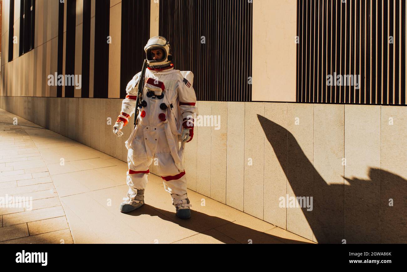 spaceman in una stazione futuristica. Uomo con tuta spaziale che cammina in una zona urbana Foto Stock