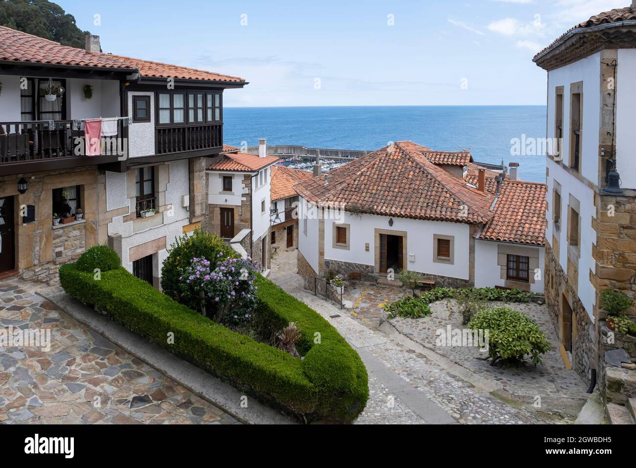 Strette strade del quartiere storico di Lastres, Asturie, Spagna, con le sue tipiche stradine acciottolate e il porto e il mare sullo sfondo, fi Foto Stock