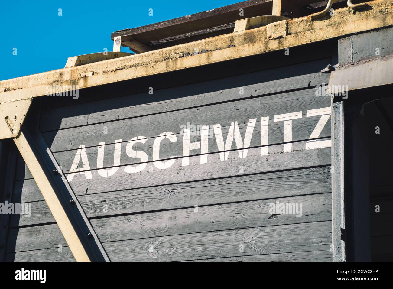 Auschwitz scritto in grandi lettere bianche su un carro di legno di un vecchio treno merci originale sulla piattaforma di scarico a Birkenau-Auschwitz Foto Stock