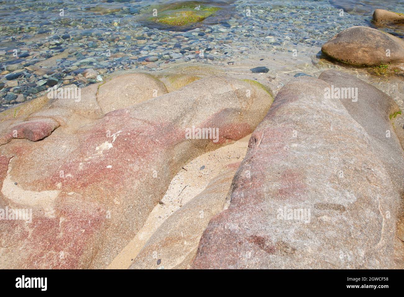 Rocce sulla spiaggia nel villaggio di Algajola o in Corsica nella zona Balagne in estate Foto Stock