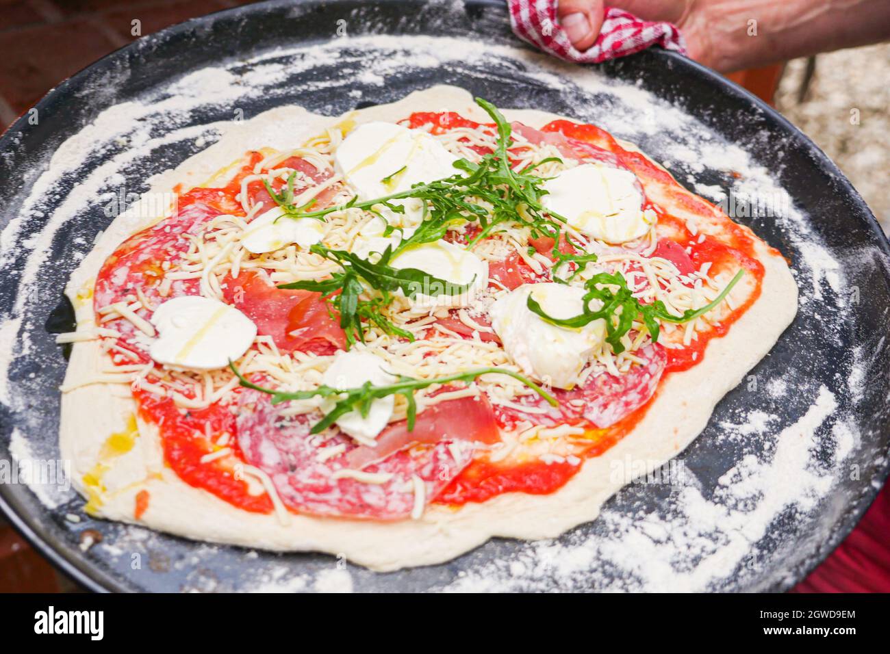 Pizza cruda su teglia da forno con prosciutto di rucola e formaggio Foto  stock - Alamy