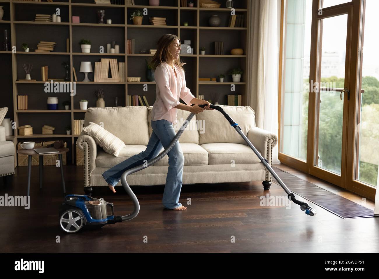 Buon giovane casa pulizia pavimenti parquet con aspirapolvere Foto stock -  Alamy