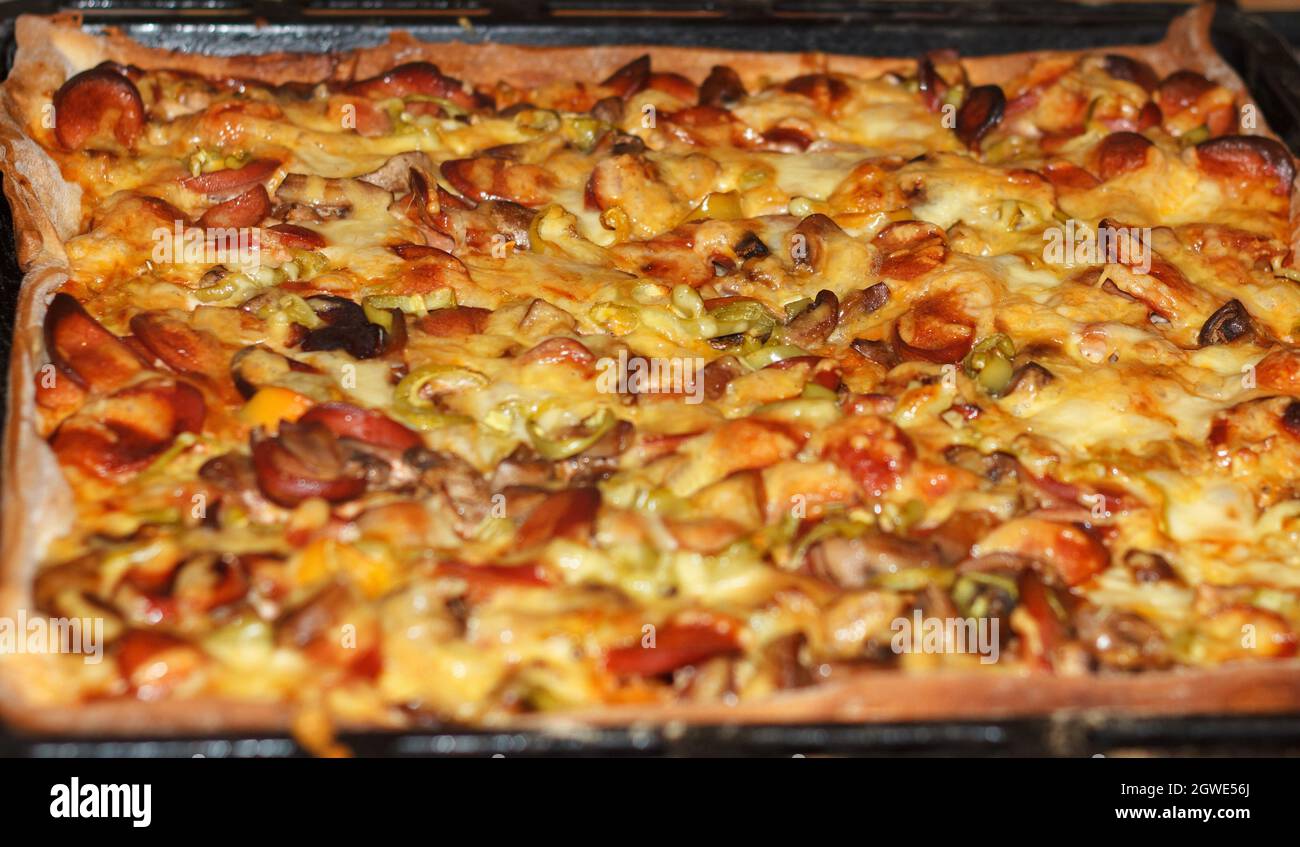 Pizza al forno con funghi, carne e formaggio fuso Foto Stock