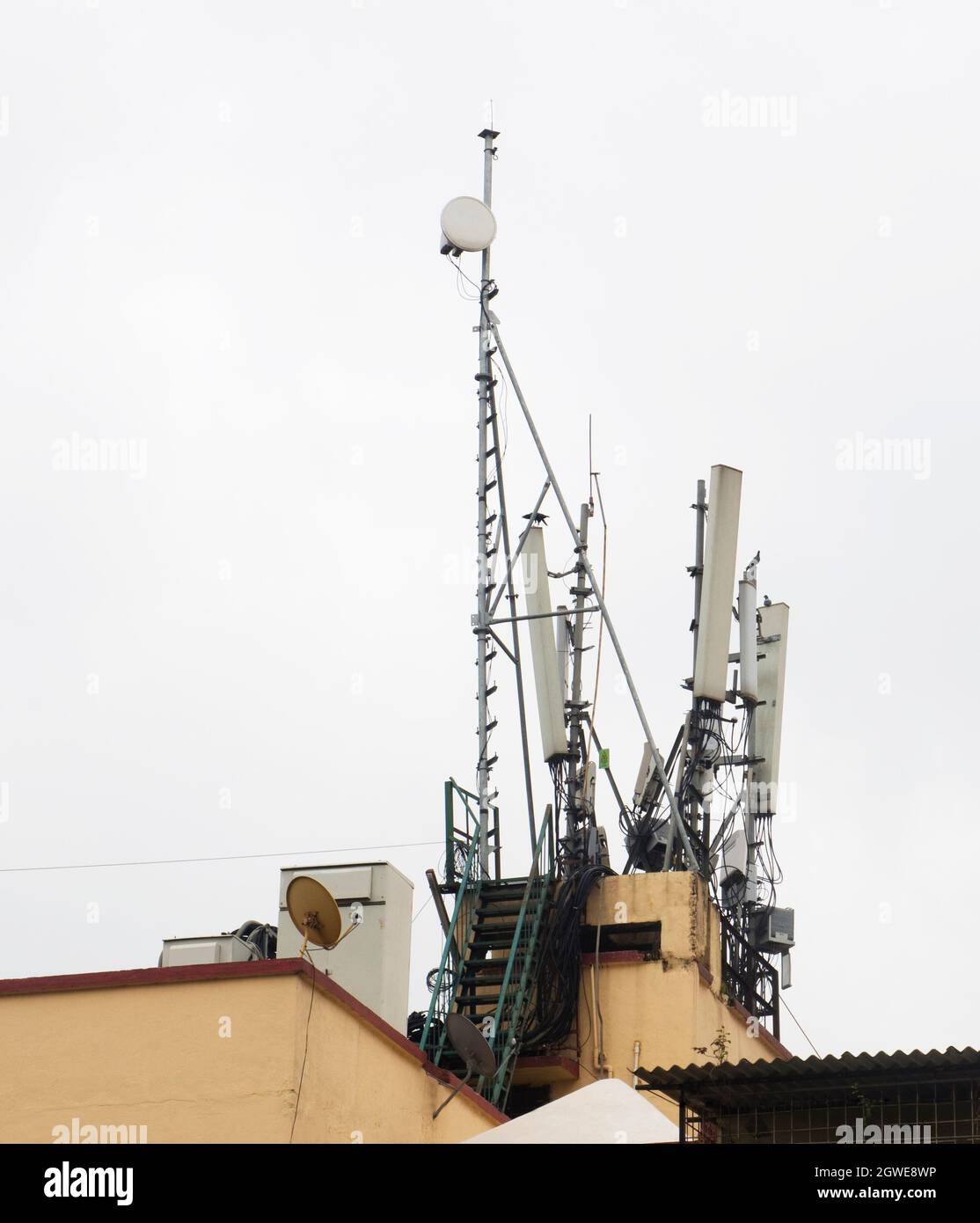 Antenna parabolica per la ricezione del segnale satellitare mobile installata sulla parte superiore di un edificio sul tetto Foto Stock