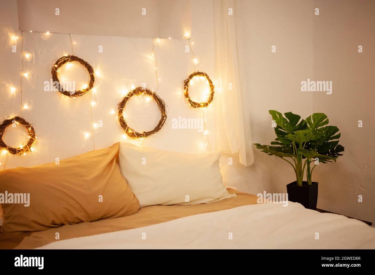 Zona foto di Natale, camera da letto. Letto con due cuscini, impianto Home  Monstera. Le pareti Foto stock - Alamy