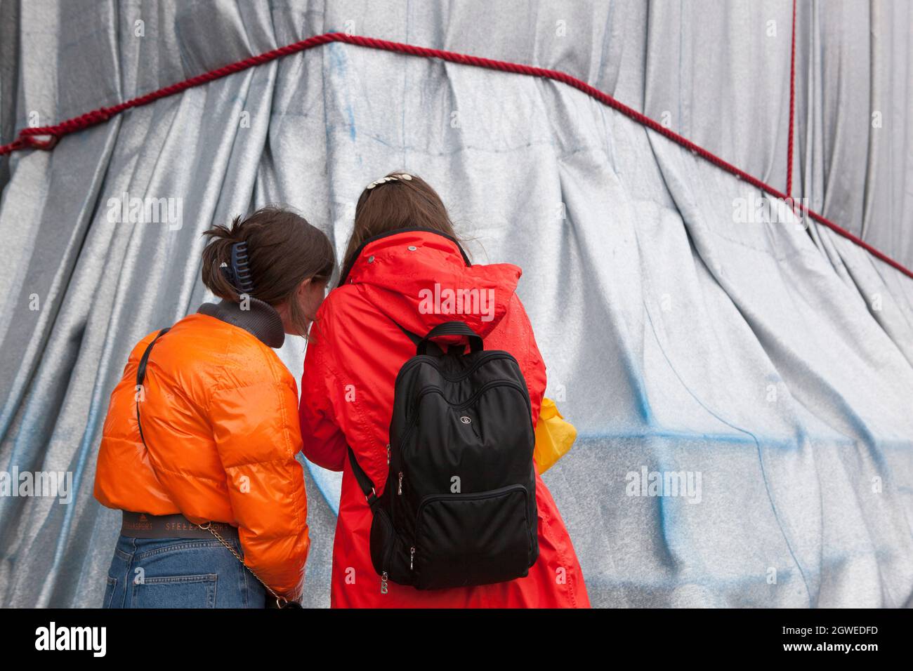 Parigi, Francia, 3 ottobre 2021: L'ultimo giorno dell'Arco di Trionfo avvolto da Christo e Jeanne-Claude non tenne lontane le folle. Con la pioggia mac e ombrelloni, turisti e amanti dell'arte si sono accordati sulla Place Charles de Gaulle, che è stato pedonale per il fine settimana. Molti hanno posto per selfie. Altri hanno guardato da vicino le corde rosse e il tessuto blu dipinto in argento e hanno tolto le piazze campione date via dagli stewards. Anna Watson/Alamy Live News Foto Stock