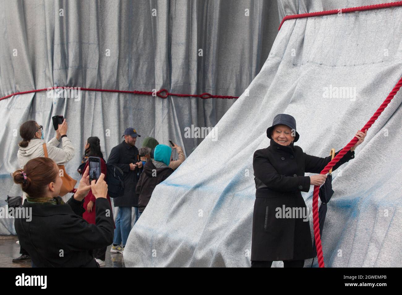 Parigi, Francia, 3 ottobre 2021: L'ultimo giorno dell'Arco di Trionfo avvolto da Christo e Jeanne-Claude non tenne lontane le folle. Con la pioggia mac e ombrelloni, turisti e amanti dell'arte si sono accordati sulla Place Charles de Gaulle, che è stato pedonale per il fine settimana. Molti hanno posto per selfie. Altri hanno guardato da vicino le corde rosse e il tessuto blu dipinto in argento e hanno tolto le piazze campione date via dagli stewards. Anna Watson/Alamy Live News Foto Stock