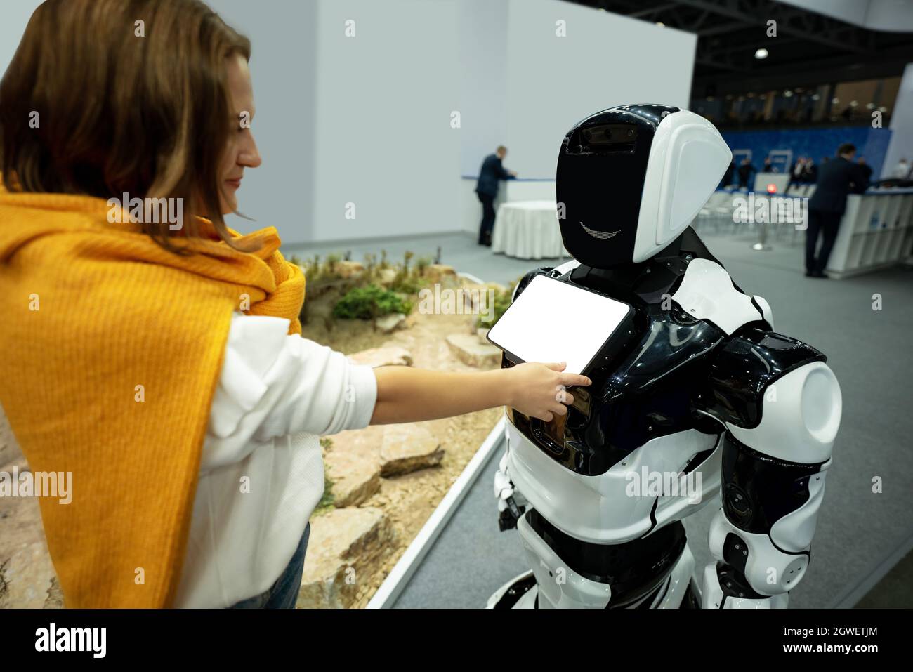 Donna che utilizza un touchscreen di un robot addetto alla reception Foto Stock