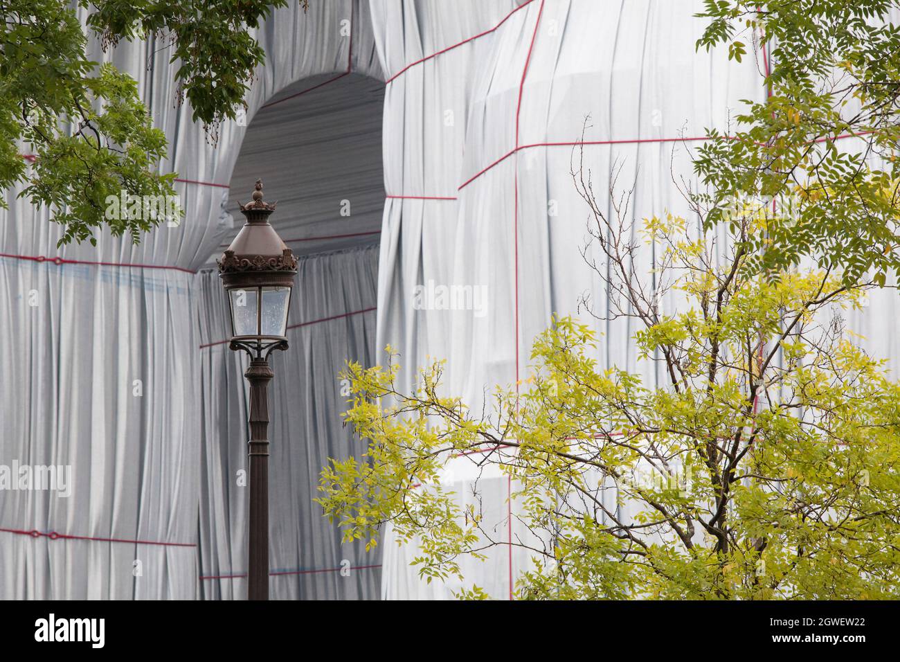 Parigi, Francia, 3 ottobre 2021: L'ultimo giorno dell'Arco di Trionfo avvolto da Christo e Jeanne-Claude non tenne lontane le folle. Con la pioggia mac e ombrelloni, turisti e amanti dell'arte si sono accordati sulla Place Charles de Gaulle, che è stato pedonale per il fine settimana. Molti hanno posto per selfie. Altri hanno guardato da vicino le corde rosse e il tessuto blu dipinto in argento e hanno tolto le piazze campione date via dagli stewards. Anna Watson/Alamy Live News Foto Stock