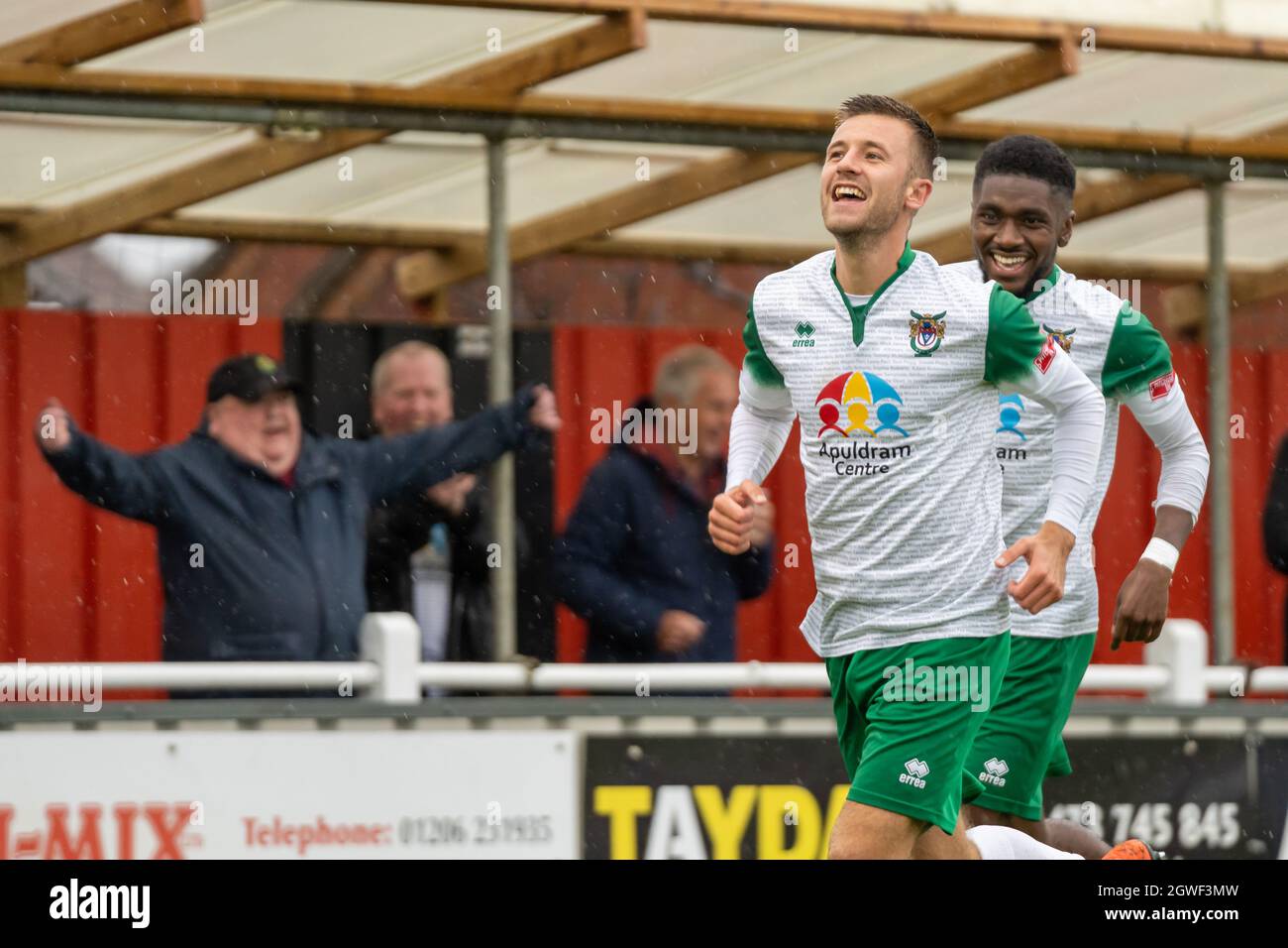 Brightlingsea, Regno Unito, 2 ottobre 2021. Azione di calcio (calcetto) della Isthmian Premier League (Southern) con gli ospiti del Bognor Regis Town FC che ha vinto 5-0 oltre ospita il Brightlingsea Regent FC. Ashton Leigh e Nathan Odoconyero (dietro) festeggiano un traguardo nella pioggia battente. Credit: Lyn Phillips/Alamy Live News Foto Stock