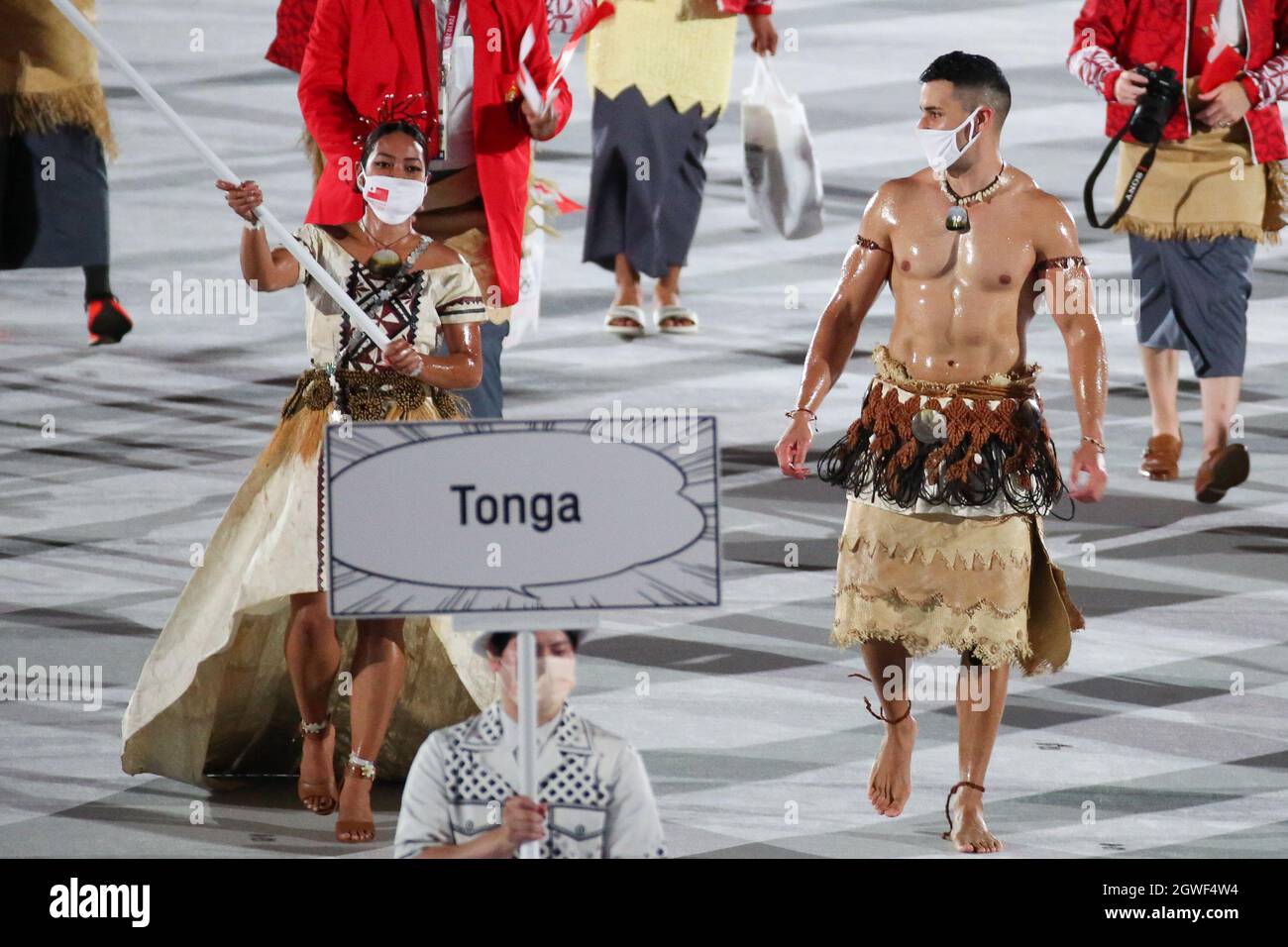 23 LUGLIO 2021 - TOKYO, GIAPPONE: I portacolori di bandiera Tonga Malia Paseka e Pita Taufatofua entrano nello Stadio Olimpico con la loro delegazione durante il Parad Foto Stock