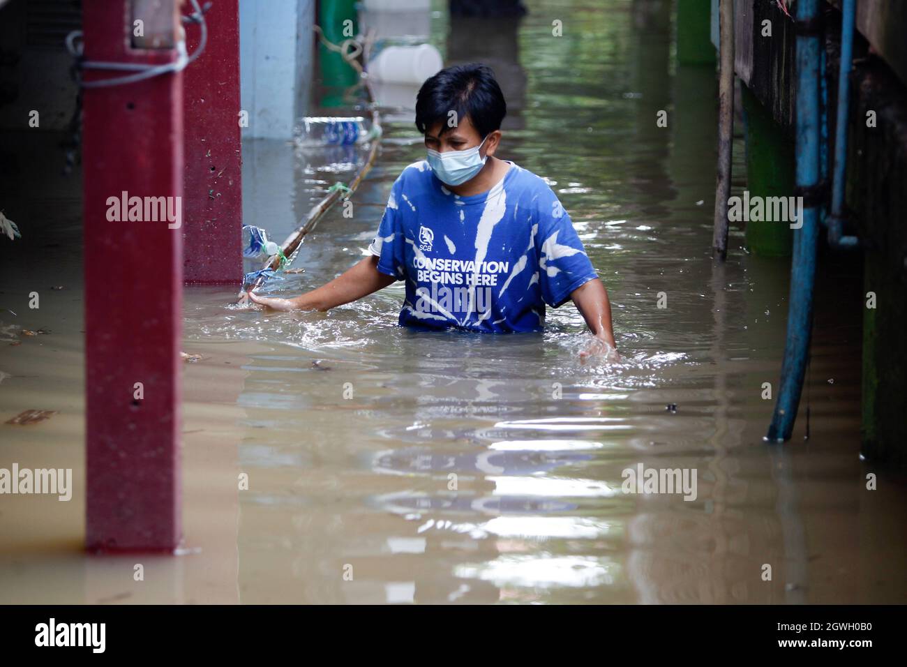 Un residente vade attraverso la casa allagata come acqua trabocca dal fiume Chao Phraya nella provincia di Pathum Thani. L'influenza della tempesta di Dianmu che colpisce il paese ha aumentato i timori che la mega-inondazione che ha colpito il bacino del fiume Chao Phraya 10 anni fa si ripeterà. Questo disastro ha causato danni per oltre 100 miliardi di baht. Anche se molti esperti di acqua sono venuti fuori per dissipare i timori, dicendo che il volume di acqua nel bacino di fiume è molto meno quest'anno rispetto alla grande inondazione nel 2011, ci sono tuttavia molte somiglianze. Foto Stock