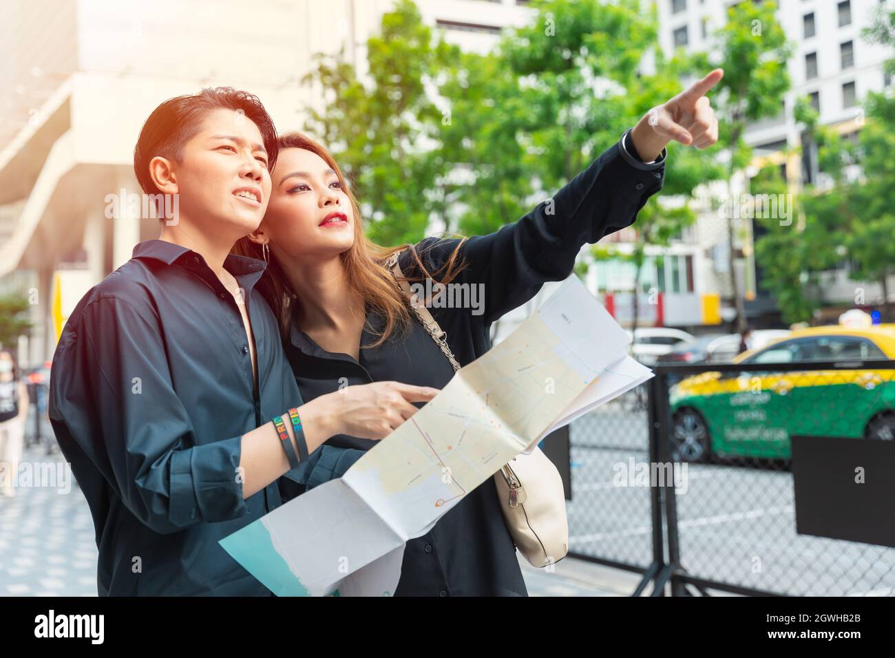 Le donne asiatiche amici viaggiare insieme aiutare a indicare luogo con mappa della città Foto Stock