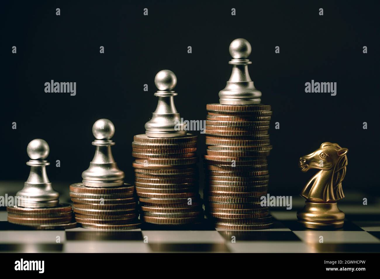 Buon team di squadra vincitore concetto di combattimento, piccolo pezzo di scacchi Pawn su moneta impilata contro Cavaliere cavallo. Foto Stock