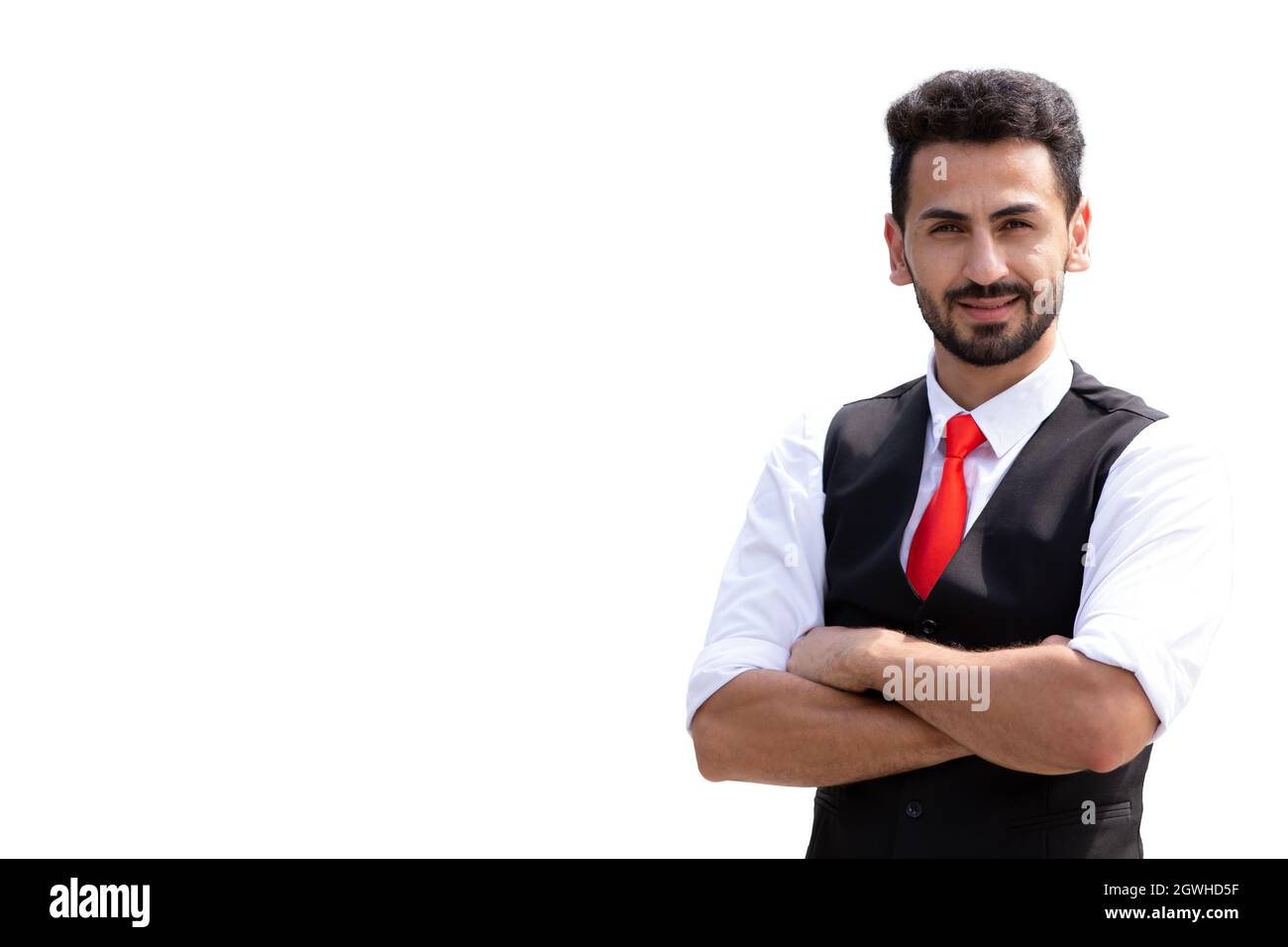 Uomo d'affari ispanico maschio in piedi sorriso braccio pieghevole sicuro isolato su sfondo bianco Foto Stock