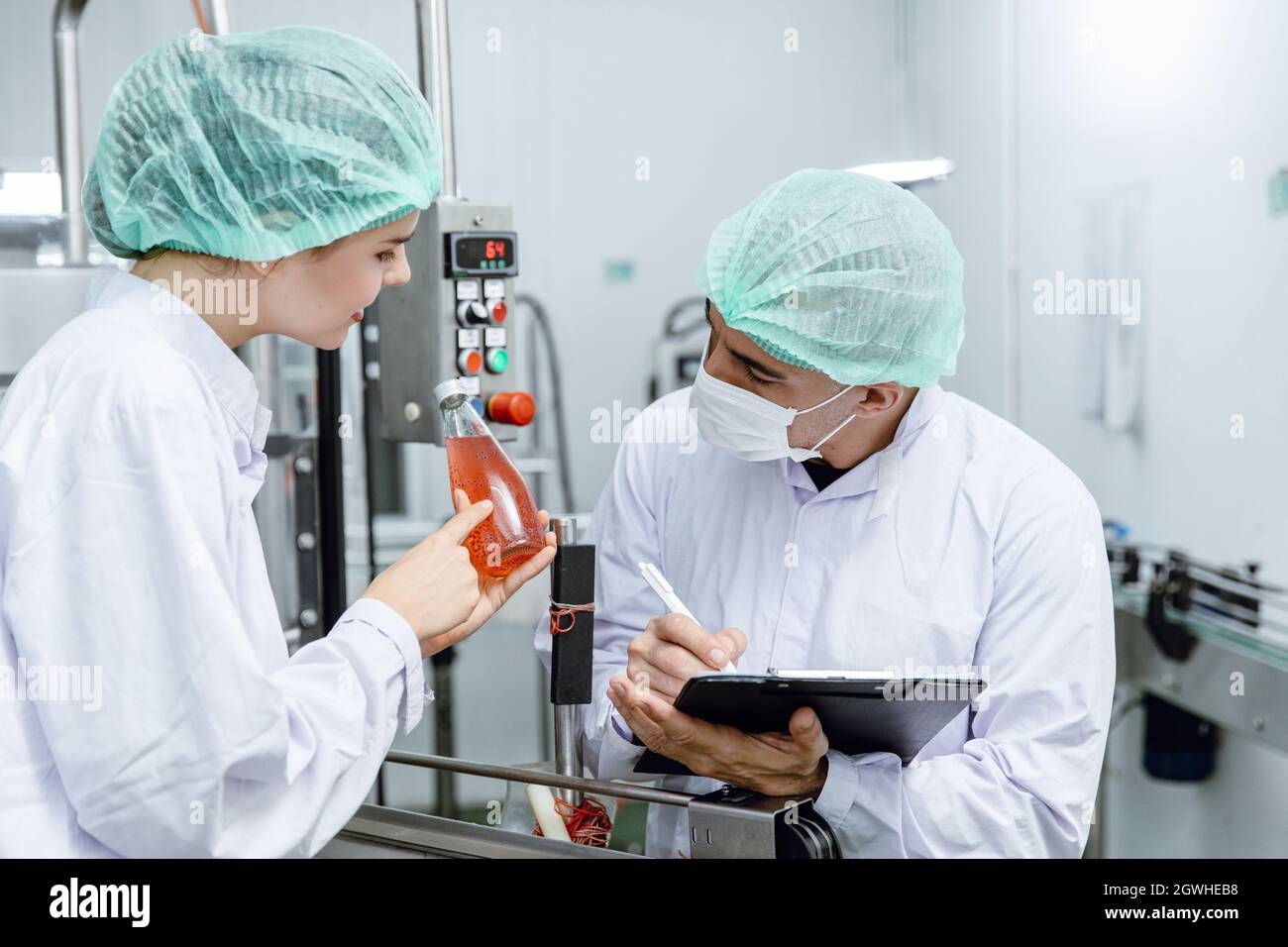 Il team di controllo qualità e sicurezza alimentare verifica lo standard di prodotto nella linea di produzione di fabbriche di alimenti e bevande. Foto Stock