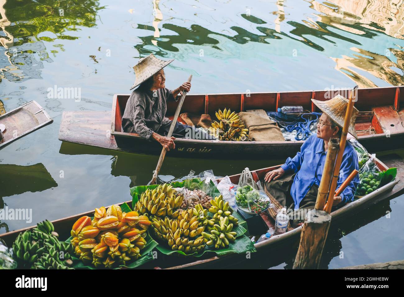 Persone vendere frutta in barca a Damnoen Saduak Floating Market in Thailandia.,27 Novembre 2020.,THAILANDIA. Foto Stock