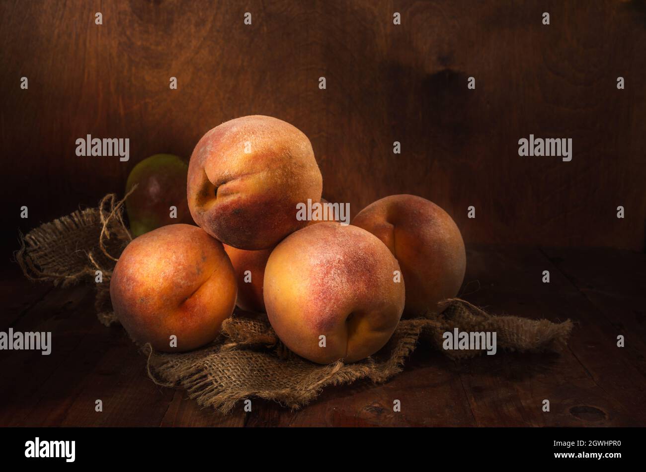pesche in gruppo su sfondo di legno scuro in stile rustico Foto Stock