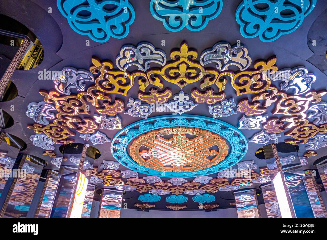 Soffitto ornamentale decorato in Centro Etnografico di Cultura storica in Turkistan. Stemma nazionale shanyrak, insegne dorate. Foto Stock