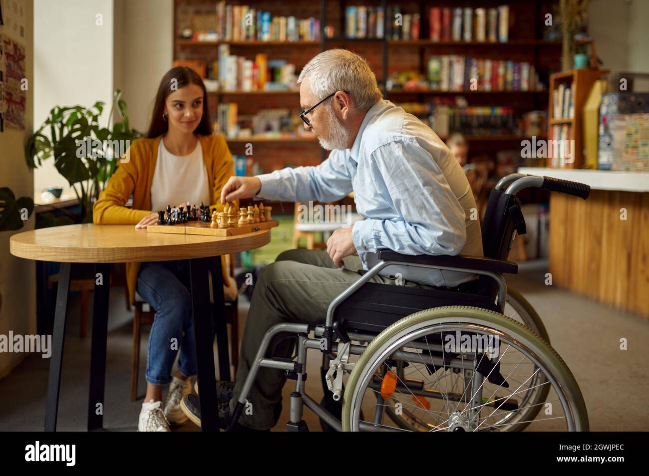 Nonno e nipote disabili giocano a scacchi Foto Stock