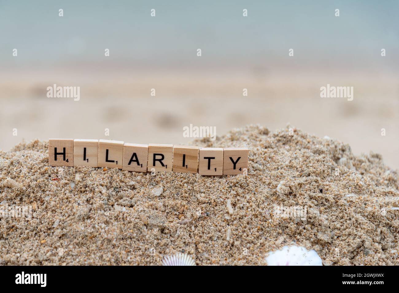 scrabble parola scritta sulla sabbia, ilarità Foto Stock