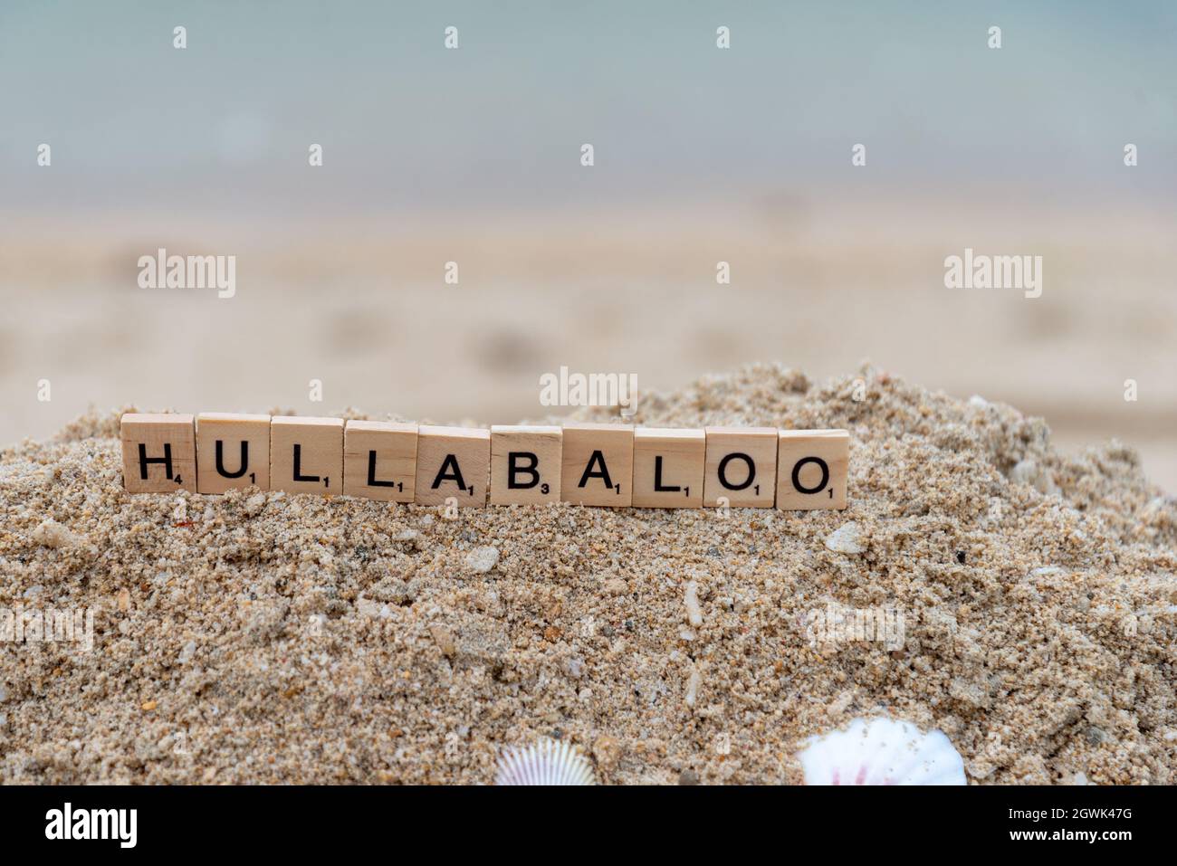 parola scrabble scritta sulla sabbia, hninlabaloo Foto Stock