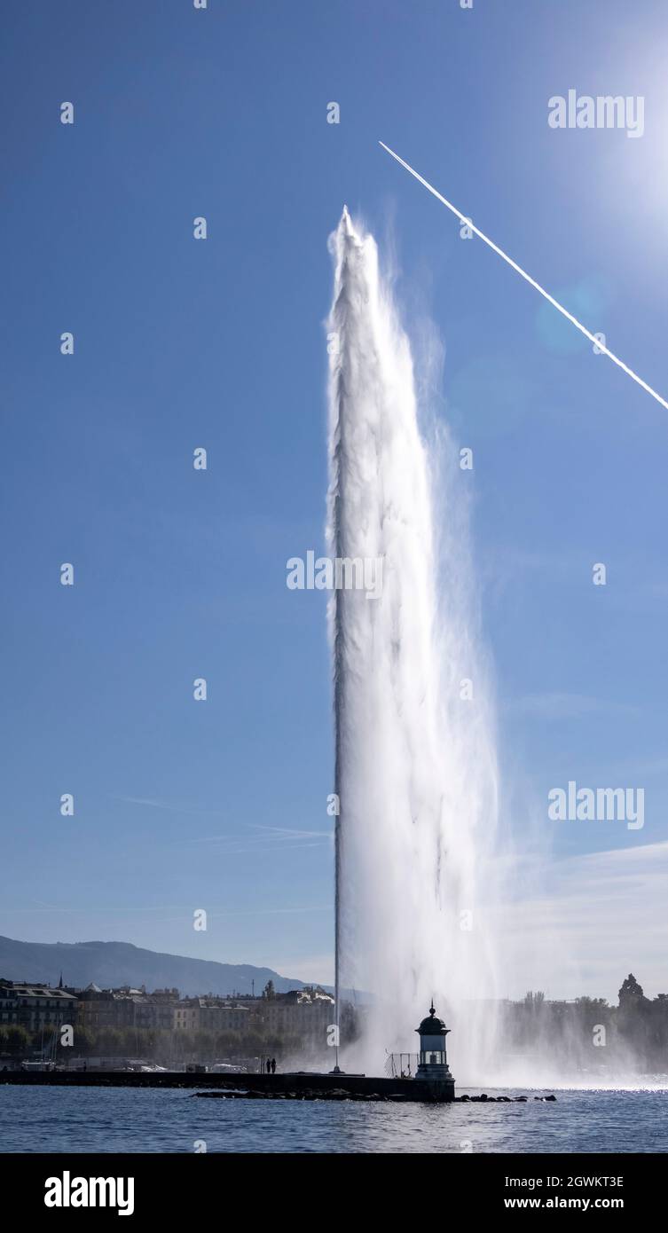Il Jet d'Eau (Water-Jet), una grande fontana a Ginevra, in Svizzera, vista con il jet trail. Foto Stock
