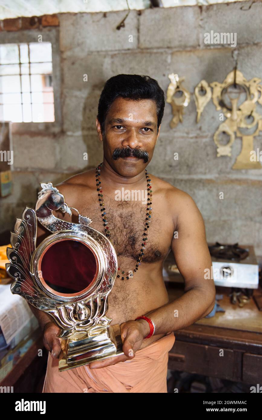 Aranmula, India - 5 dicembre 2015: Kerala, specchi d'argento produzione artigianale in zona rurale, l'uomo fa artigianato unico lavoro d'arte. Piccolo autobus per famiglie Foto Stock