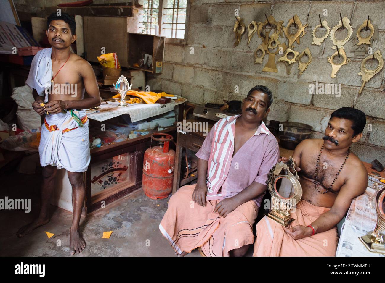 Aranmula, India - 5 dicembre 2015: Kerala. Specchi d'argento produzione fatta a mano in zona rurale, l'uomo fa artigianato unico lavoro d'arte. Piccola famiglia Foto Stock