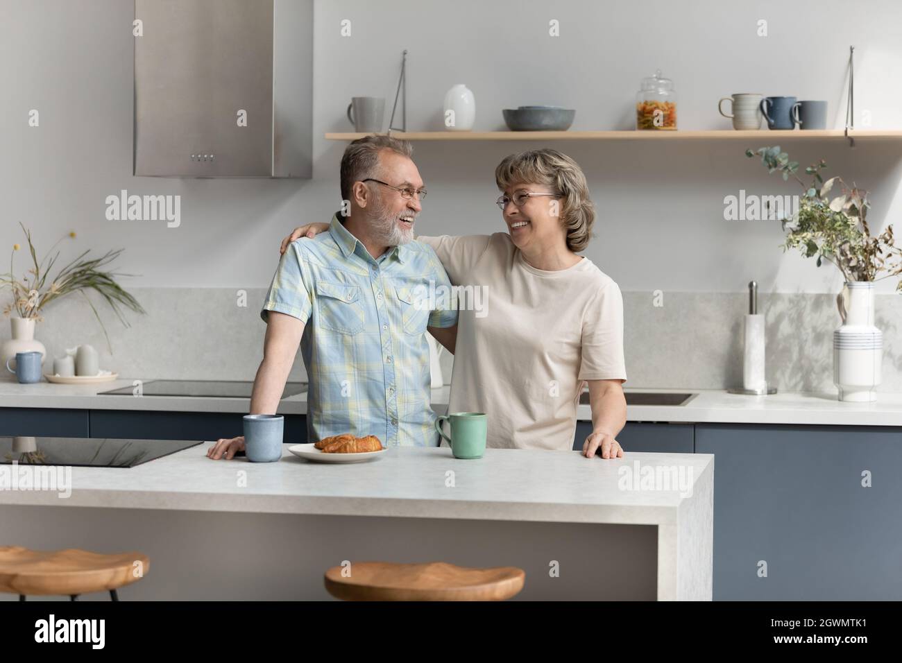 Legame affettuoso coppia più anziana parlare in cucina. Foto Stock