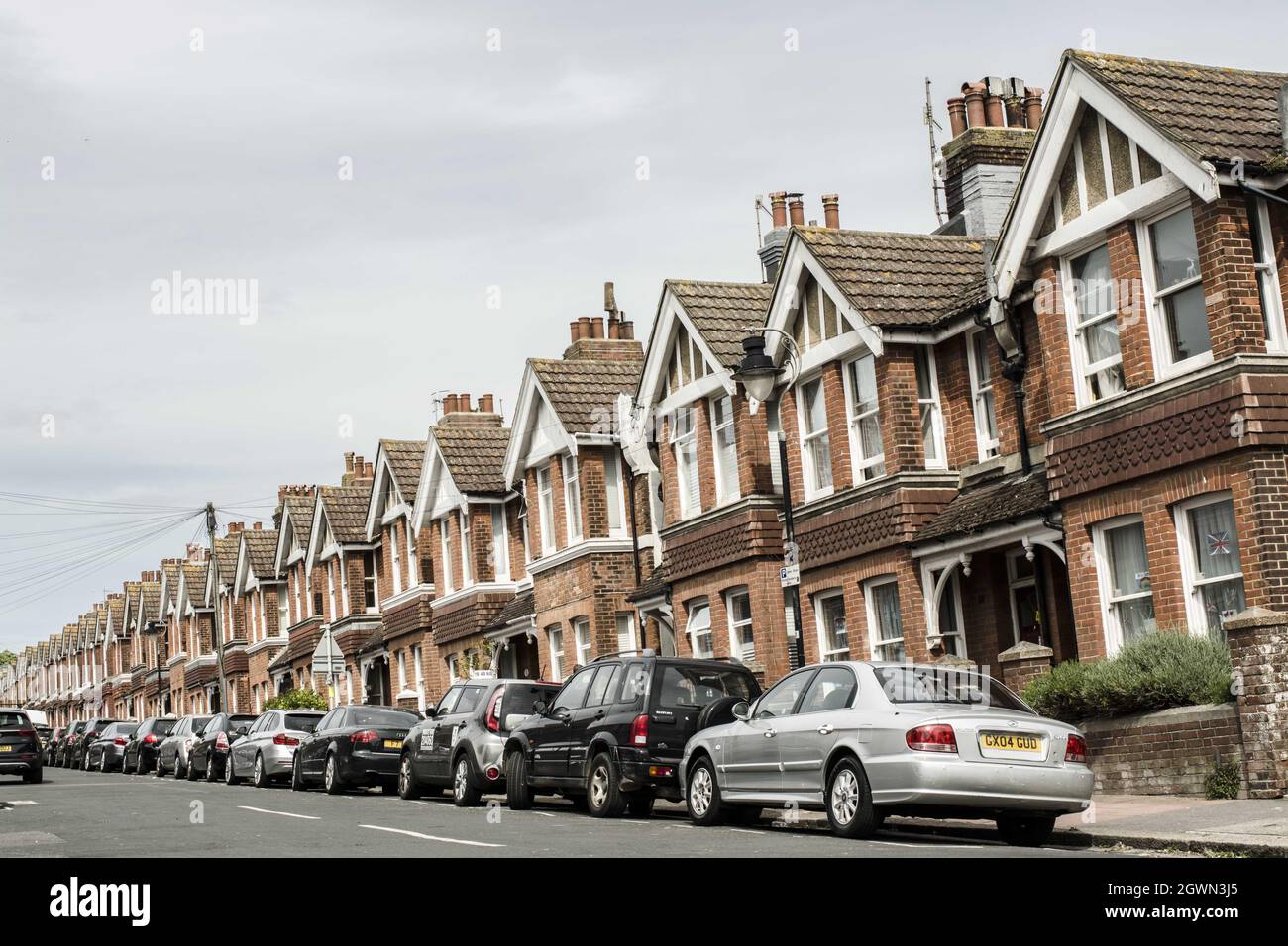 Strada con case terrazzate, automobili nella parte anteriore, Inghilterra Foto Stock