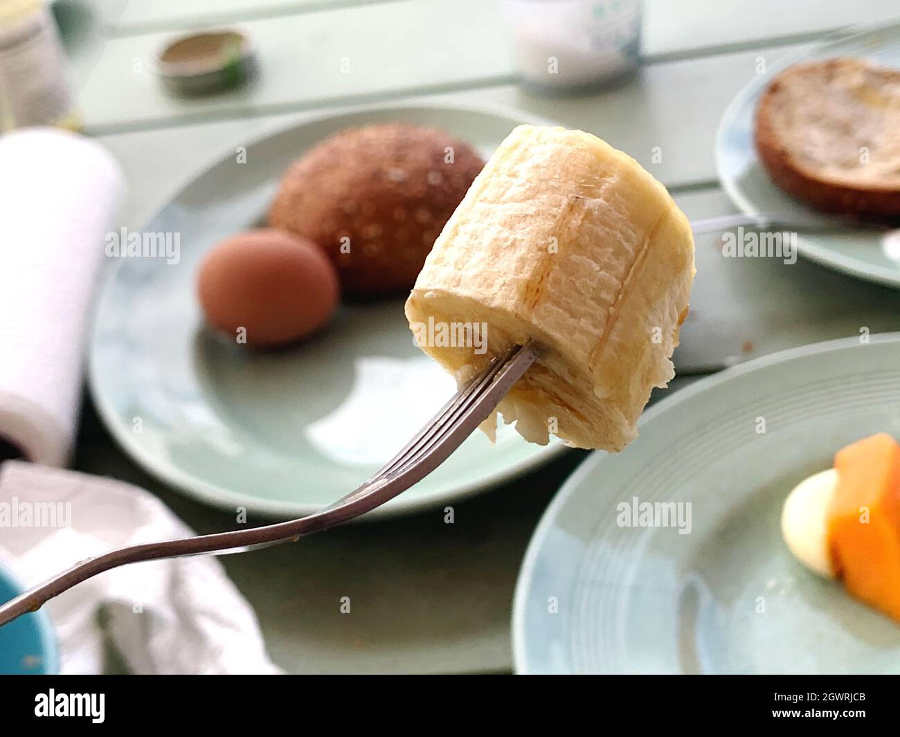 Primo piano di Banana Slice on Fork a colazione su tavolo, pronto a mangiare Foto Stock