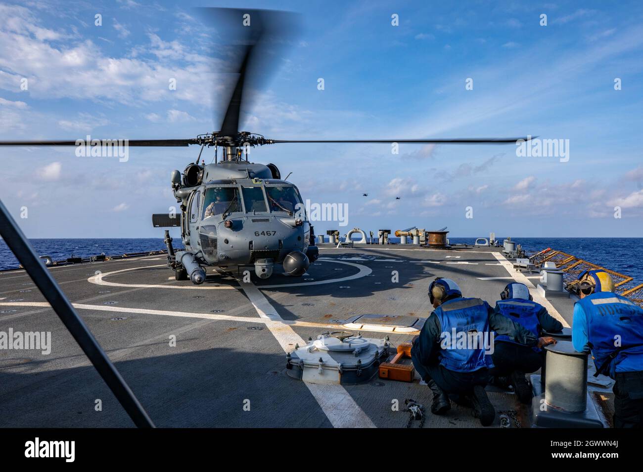 MAR DELLE FILIPPINE (settembre 15, 2021) Un'aeronautica statunitense HH-60G Pave Hawk conduce le qualifiche di atterraggio sul ponte di volo a bordo del cacciatorpediniere missilistico guidato di classe Arleigh Burke USS Barry (DDG 52). Barry è assegnato al Comandante, Task Force (CTF) 71/Destroyer Squadron (DESRON) 15, il più grande DESRON dispiegato in avanti della Marina e la principale forza di superficie della 7a flotta statunitense. (STATI UNITI Foto Navy di Mass Communication Specialist terza classe Justin Stack) Foto Stock